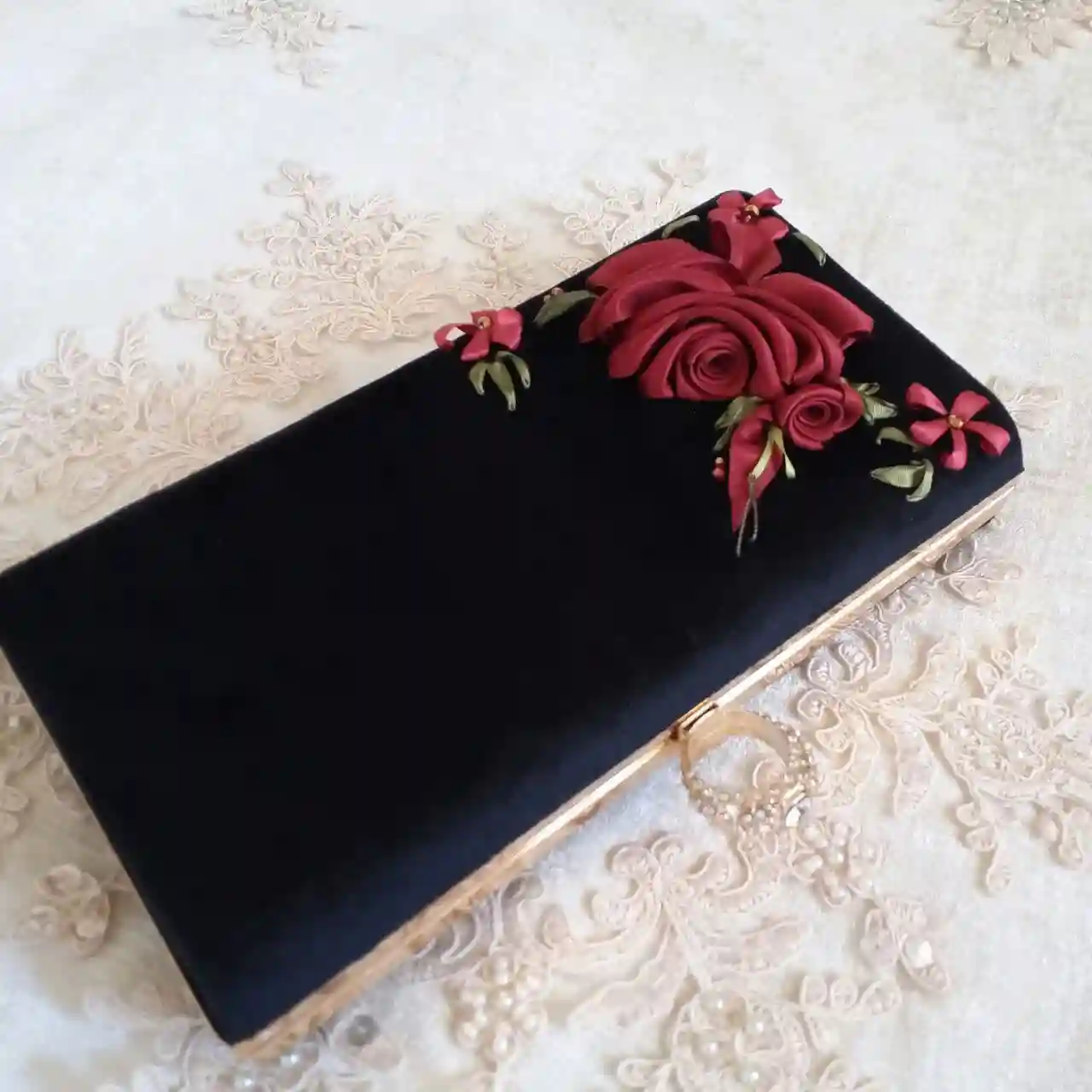 کیف مخمل مشکی با یک گل‌ رز روبانی درشت و ریز در گوشه